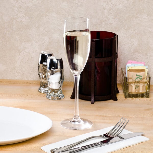 A Chef & Sommelier Cabernet flute glass on a table with a fork and knife.