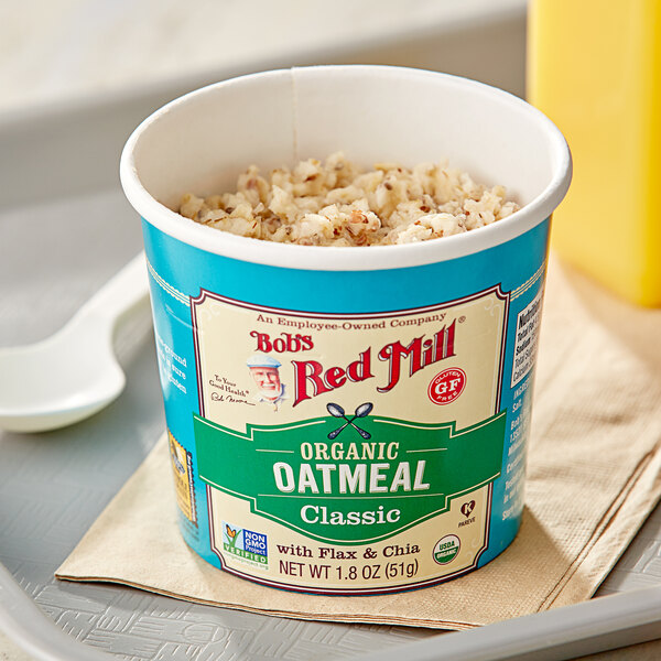 A Bob's Red Mill Classic Gluten-Free Organic Oatmeal cup with a spoon on top.