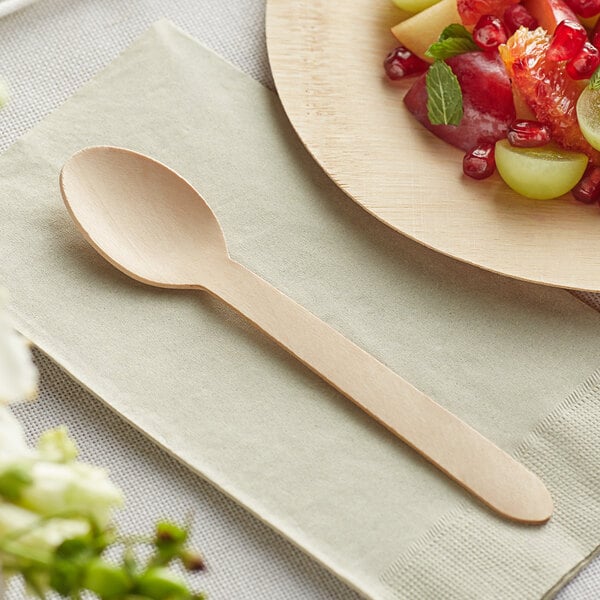 A TreeVive by EcoChoice wooden spoon on a plate of fruit