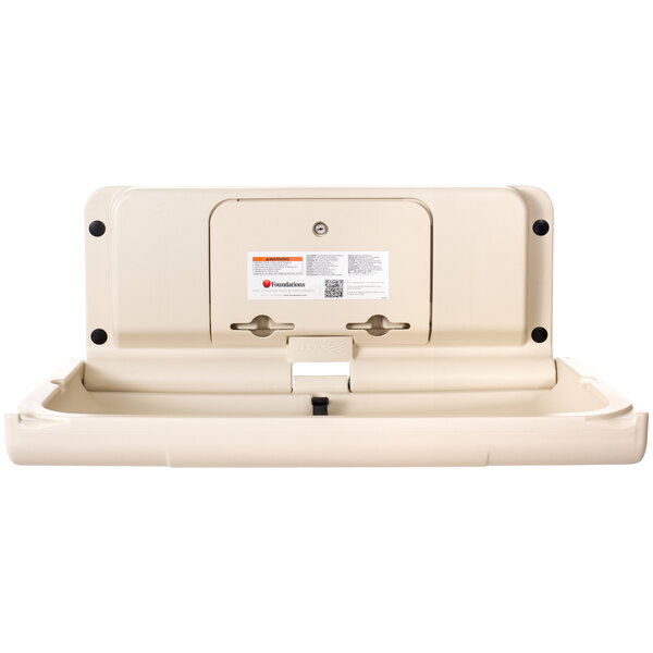 A white plastic Foundations baby changing table with a lid.