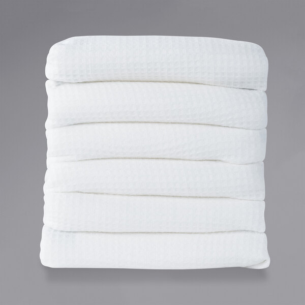 A stack of white rectangular Foundations ThermaLux baby blankets with white polysatin borders.