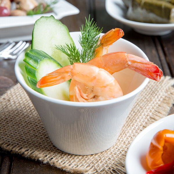 An Arcoroc Ludico deep bowl filled with shrimp and cucumber on a table.
