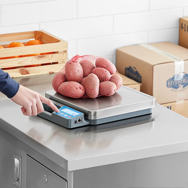 A person weighing a bag of potatoes on an AvaWeigh digital portion scale.