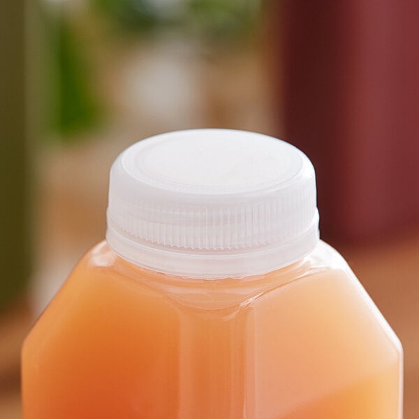 A plastic juice bottle with a clear tamper-evident cap on a table.