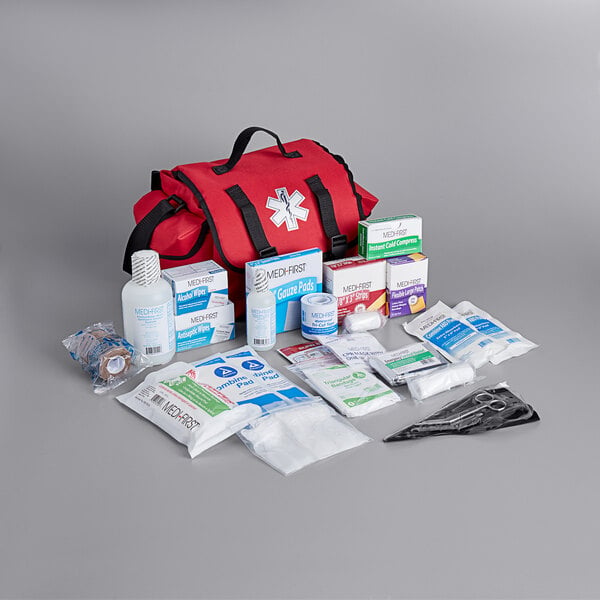 A red Medique trauma first aid kit with medical supplies.