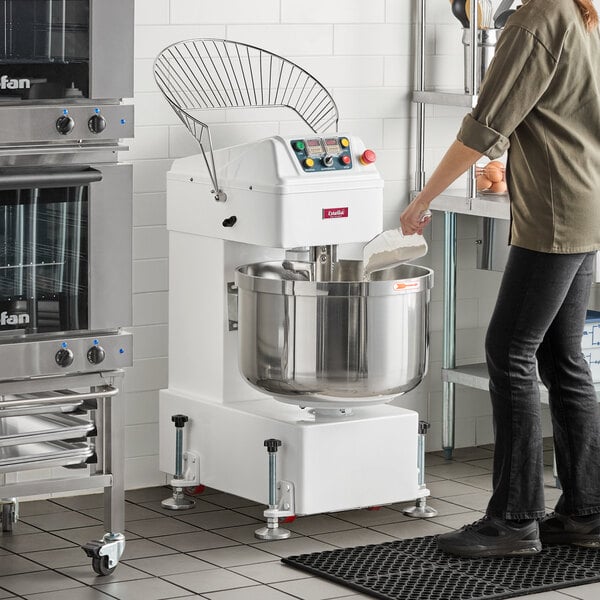 An industrial spiral dough mixer with a large stainless steel bowl and control panel, designed for commercial baking operations.