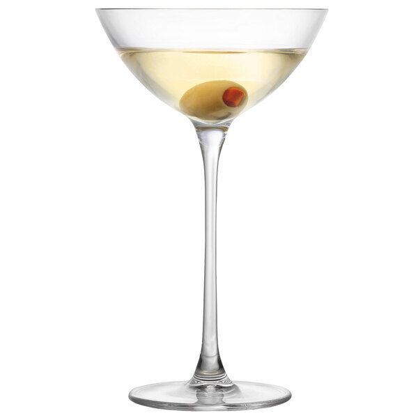A Nude Savage Coupetini glass with an olive in it.