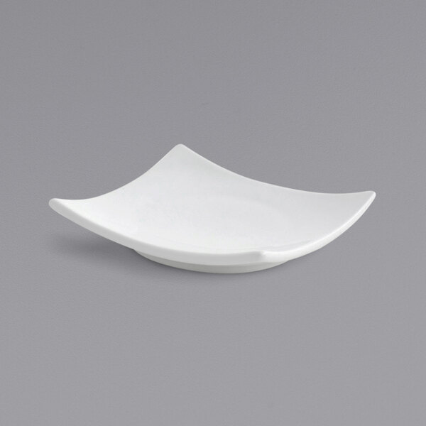 A Front of the House bright white square porcelain plate with a curved edge.