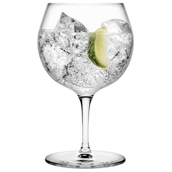A Nude Vintage gin and tonic glass with clear liquid, ice, and a lime wedge.