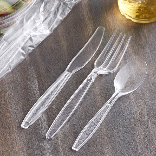 A close-up of clear plastic Visions cutlery including a fork and knife.