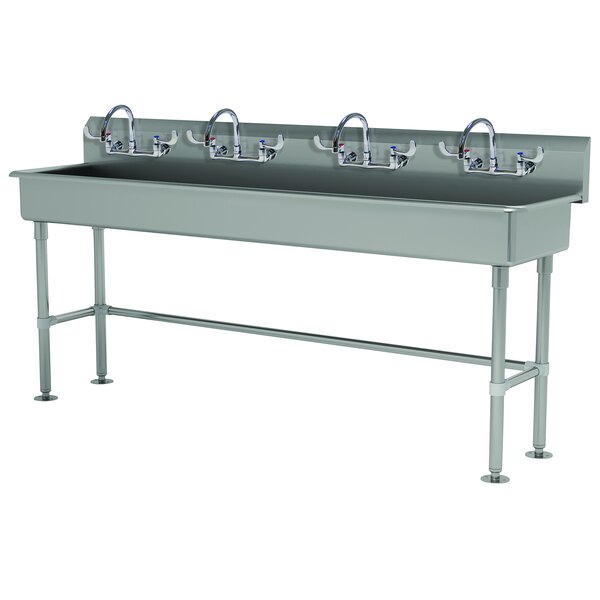 An Advance Tabco stainless steel multi-station hand sink with three faucets.