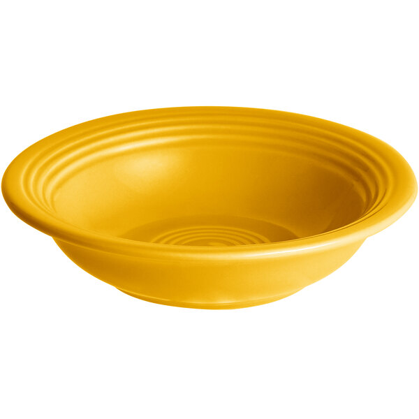 A yellow stoneware bowl with a spiral design on the rim.