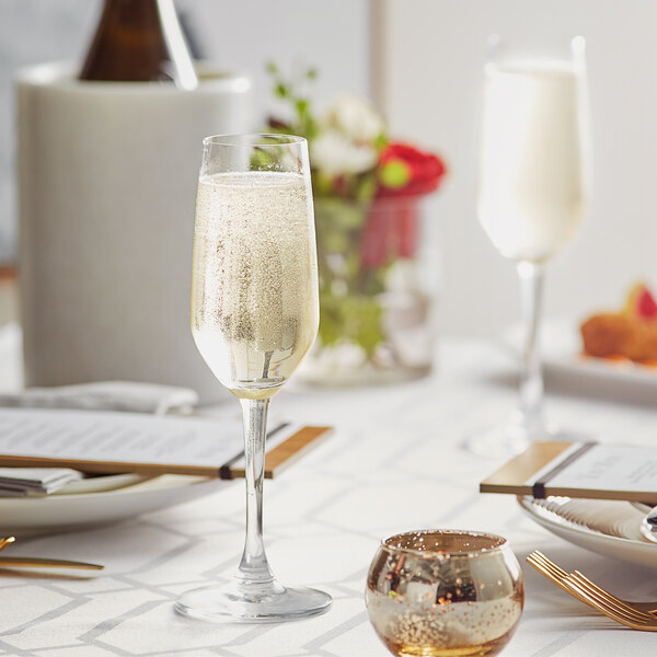 An Acopa Radiance flute glass of champagne on a table.