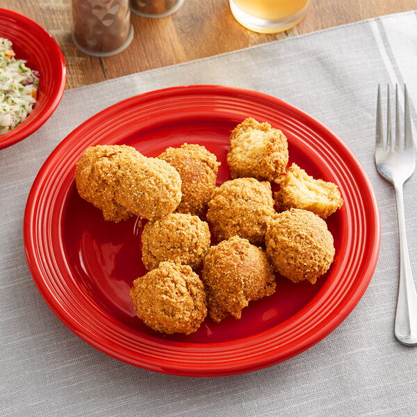 A close up of fried chicken and rice on a red Acopa Capri stoneware plate.