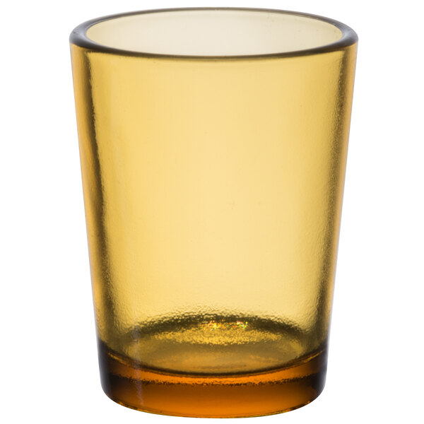 A close up of a Sterno Petite Amber Votive Glass with a yellow rim.
