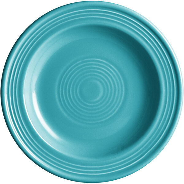 A close-up of an Acopa Capri Caribbean Turquoise stoneware plate with a spiral design in the center.