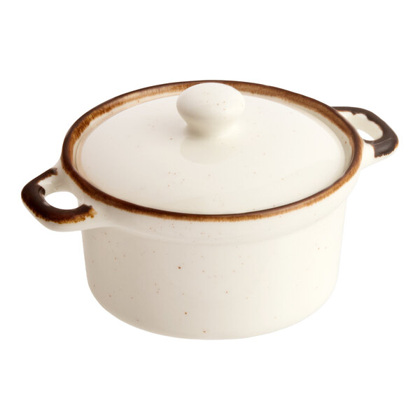 An 8 oz. vanilla bean stoneware mini casserole dish with a lid and two handles.