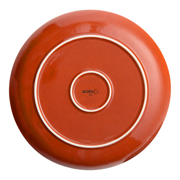 A round, orange porcelain coupe plate with a smooth finish and the Acopa brand name on the bottom.