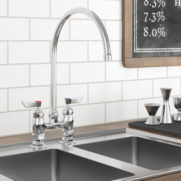 A Waterloo deck mount faucet with a gooseneck spout on a counter above a sink with a black chalkboard.