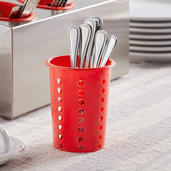 A red plastic flatware holder with silverware in it.