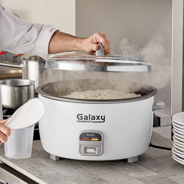 A man using a Galaxy commercial rice cooker to prepare food.