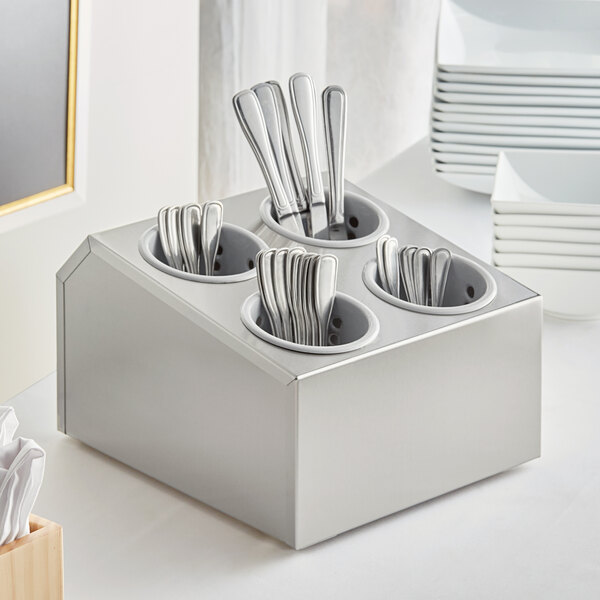 A stainless steel flatware organizer with gray perforated plastic cylinders holding silverware.