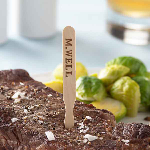 A steak with a TreeVive by EcoChoice wooden stick in it.