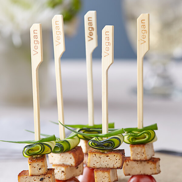 Bamboo food picks on a plate of food at a catering event.