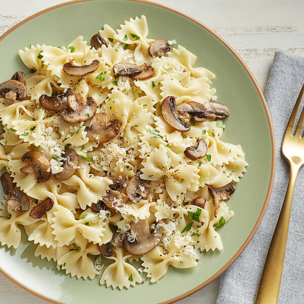 A plate of Barilla farfalle pasta with mushrooms and parmesan cheese.