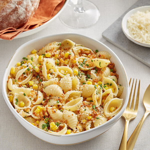 A bowl of Barilla conchiglie rigati pasta with corn and cheese.