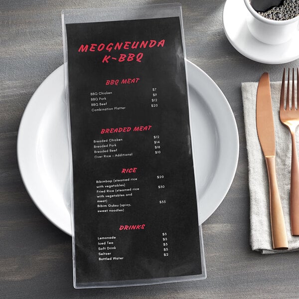 A clear menu cover with a black and white menu on a plate with a fork and knife.