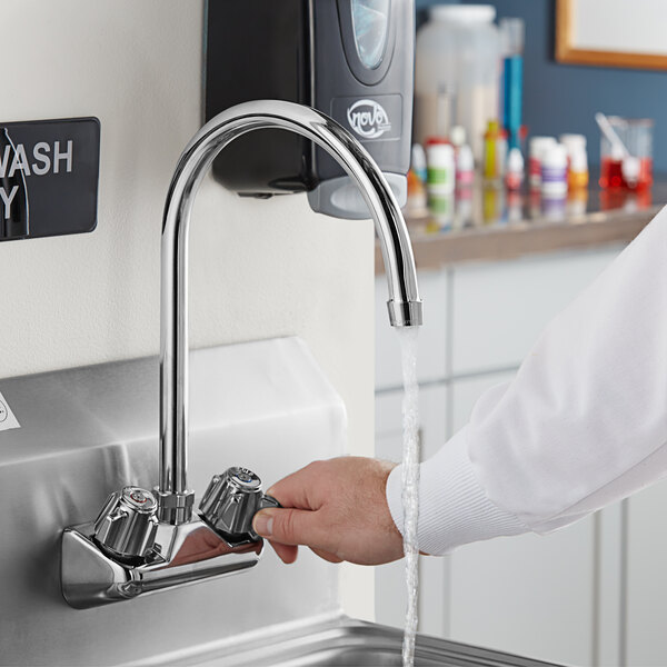A person using an 8" long gooseneck spout faucet to wash their hands.