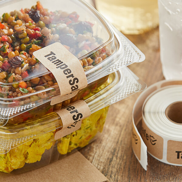 A container of food with a TamperSafe Kraft paper label next to a roll of TamperSafe labels.