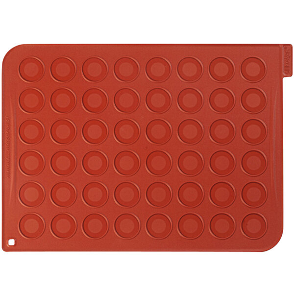 A red silicone baking mat with circles.