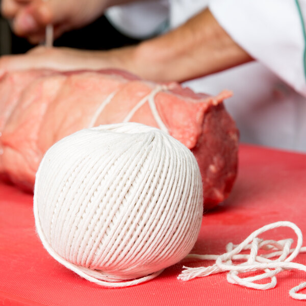 A ball of Choice 24 Gauge Butcher Sausage Twine on a red surface.