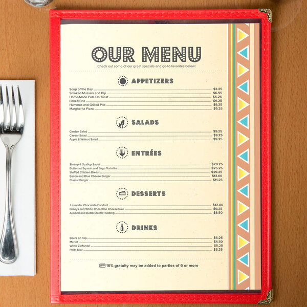 Menu paper with a Southwest themed fiesta border on a wooden table with a fork and knife.