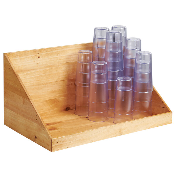 A wooden rack holding clear plastic cups.