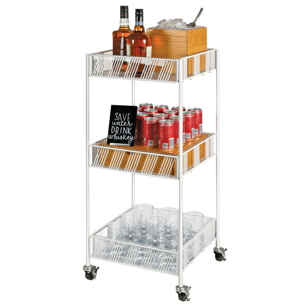 A white metal Cal-Mil Portland merchandiser cart with plastic inserts holding bottles and glasses.