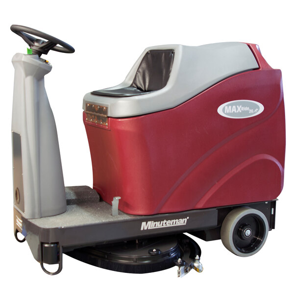 A red and gray Minuteman Max Ride 26 ECO ride-on floor scrubber machine with wheels and a handle.