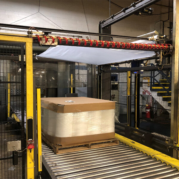 A conveyor belt with a box of Lavex Polyethylene Sheeting on it.