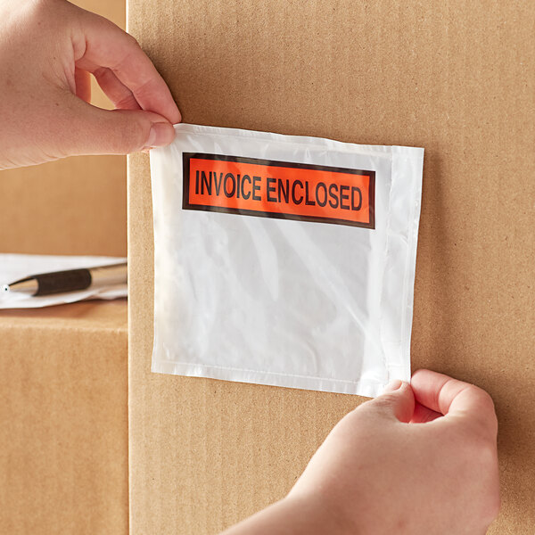 A hand holding a box of Lavex printed polyethylene invoice packing list envelopes.