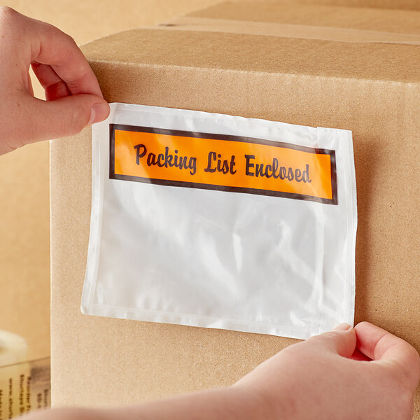 A person holding a box of Lavex printed polyethylene packing list envelopes.