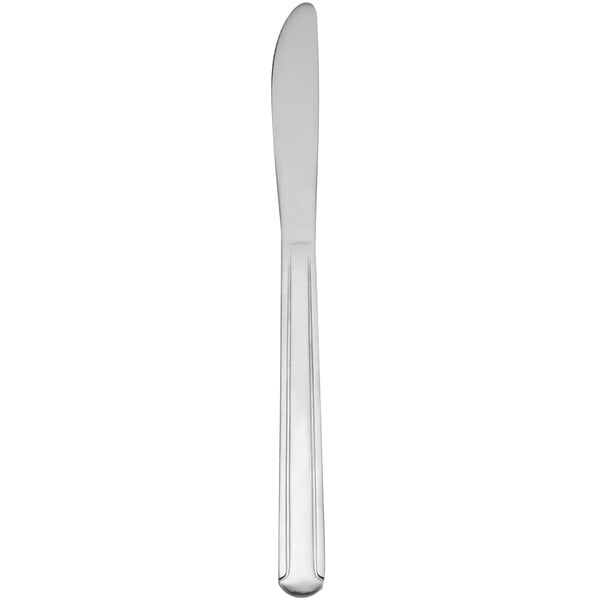 A Delco Dominion III stainless steel dinner knife with a white handle.