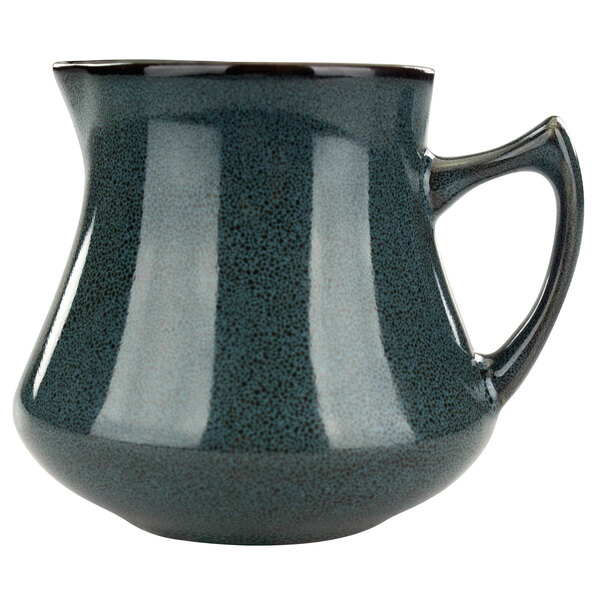 A close-up of an International Tableware Luna midnight blue porcelain creamer with a black handle.