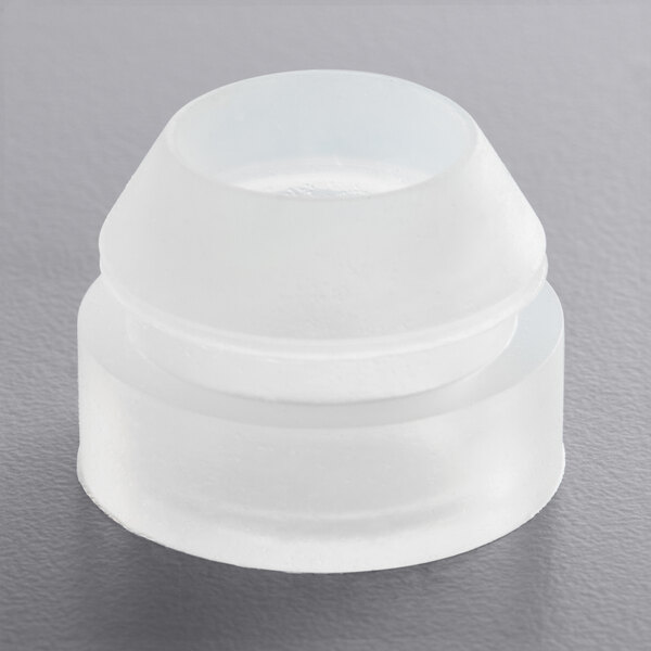 A clear plastic round grommet for a Bunn coffee brewer on a gray surface.