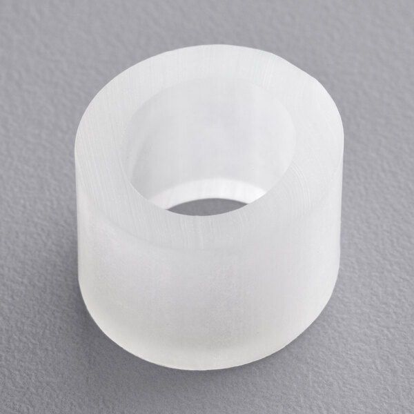 A white round plastic gasket with a hole in it.