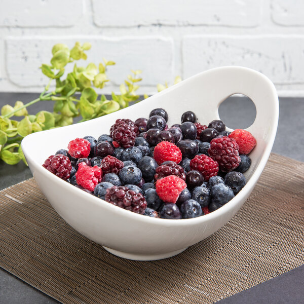 A 10 Strawberry Street Whittier white porcelain bowl filled with berries on a place mat.