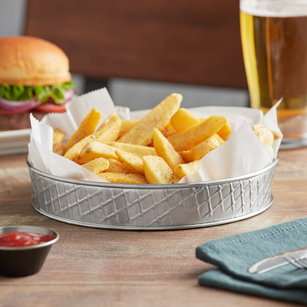 A Tablecraft lattice stainless steel platter with a burger and french fries, with a bowl of ketchup on the side.