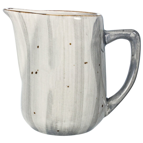A white porcelain creamer with a gray speckled design.