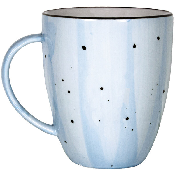 A white china mug with blue and black dots.